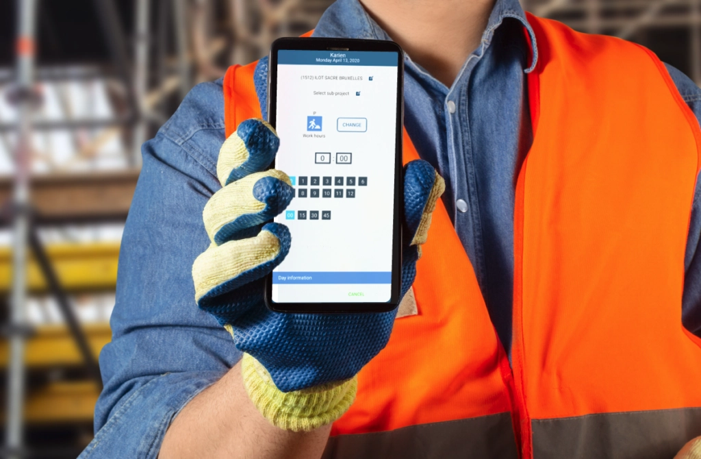 Travailleur du BTP utilisant une application de pointage chantier (une app mobile dédiée à la saisie des heures).